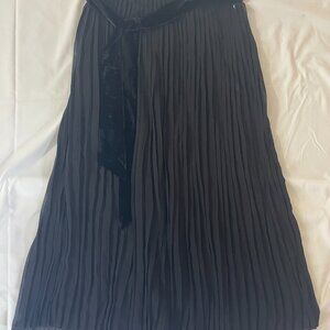 Amelie House. Long black pleated women's dress. Polyester. Made in China.